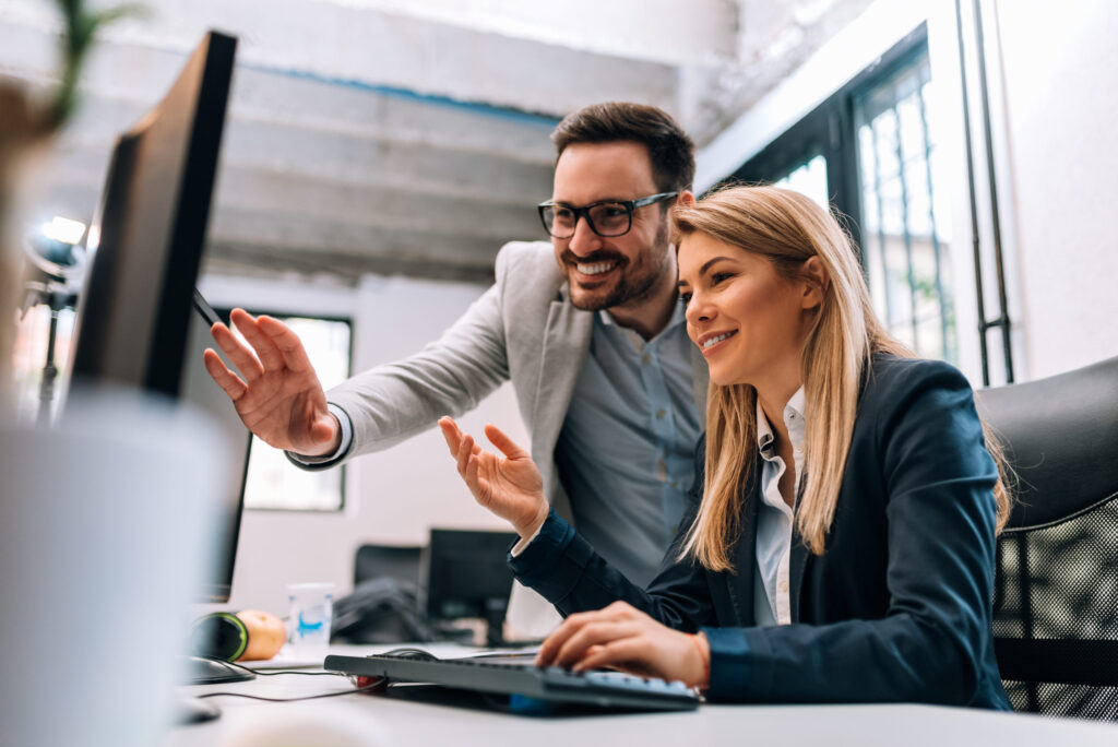 man and woman smiling at computer