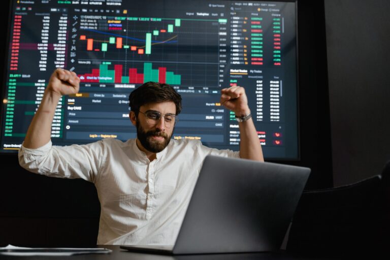happy stock trader in front of computer