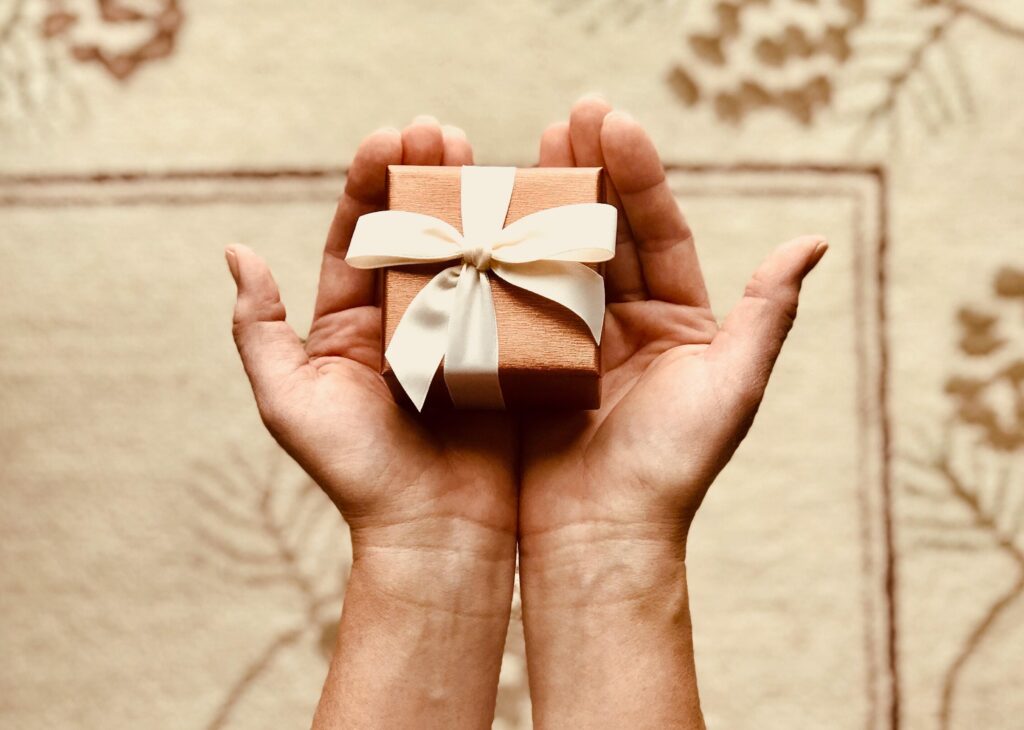 photo of two hands holding a small present