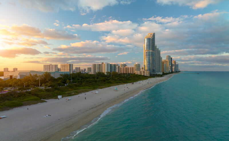View from above of luxurious highrise hotels and condos on Atlantic ocean shore in Sunny Isles Beach city in the evening. American tourism infrastructure in southern Florida
