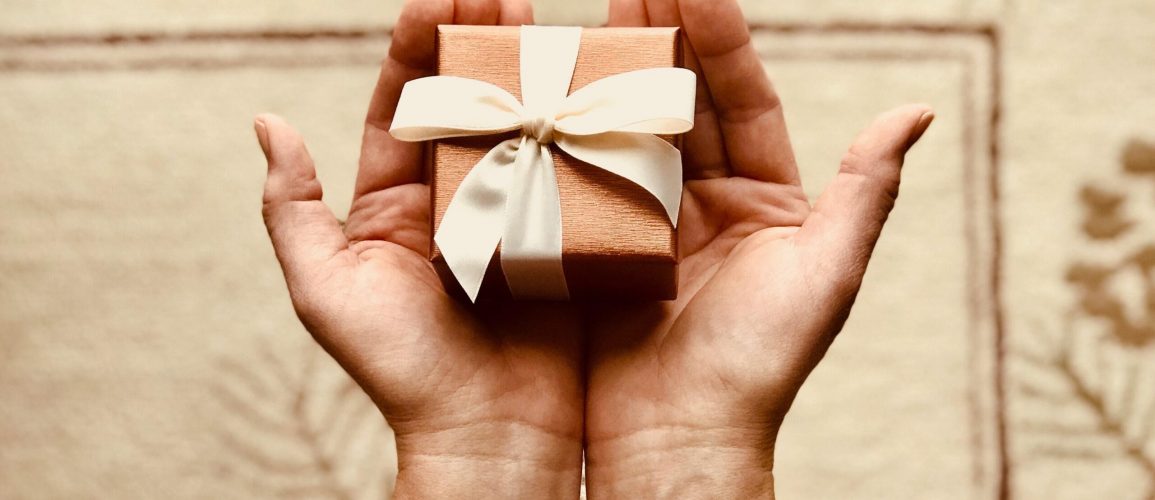 photo of two hands holding a small present